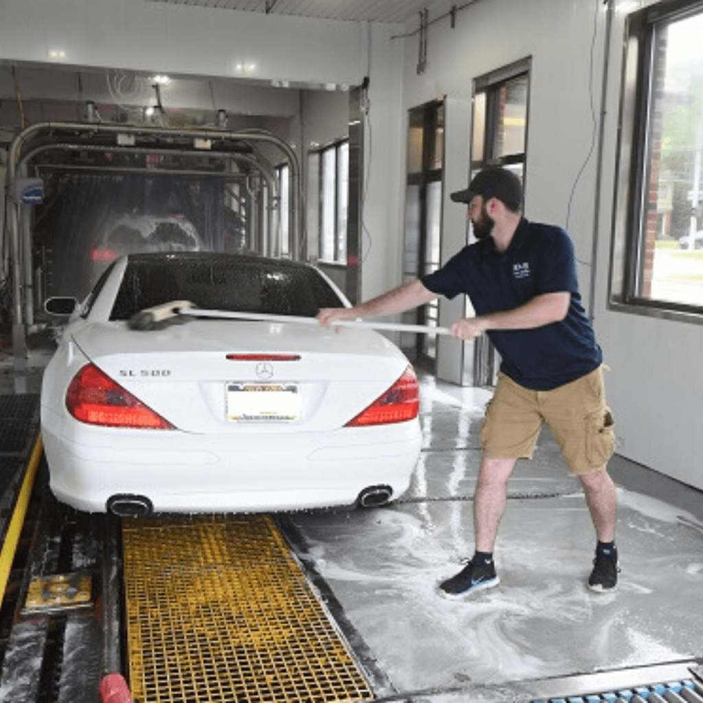 KS Car Wash employee cleaning white car
